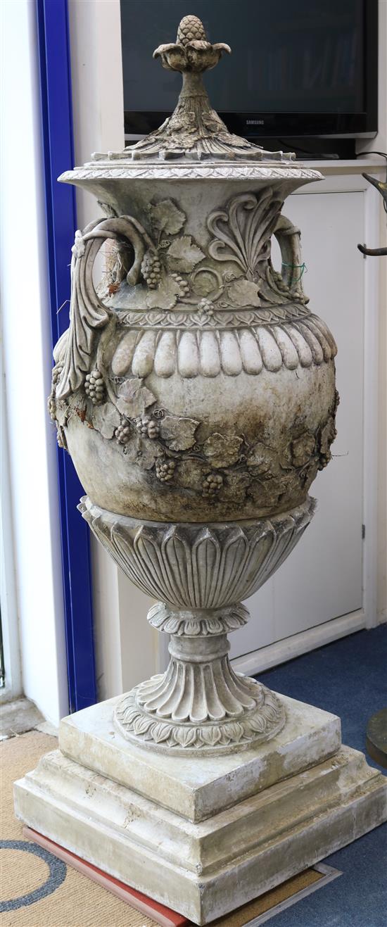 A pair of reconstituted stone Neo-Classical two handled campana shaped lidded urns, on plinths H.177cm